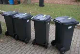 Schwarze Mülltonne auf Gehweg